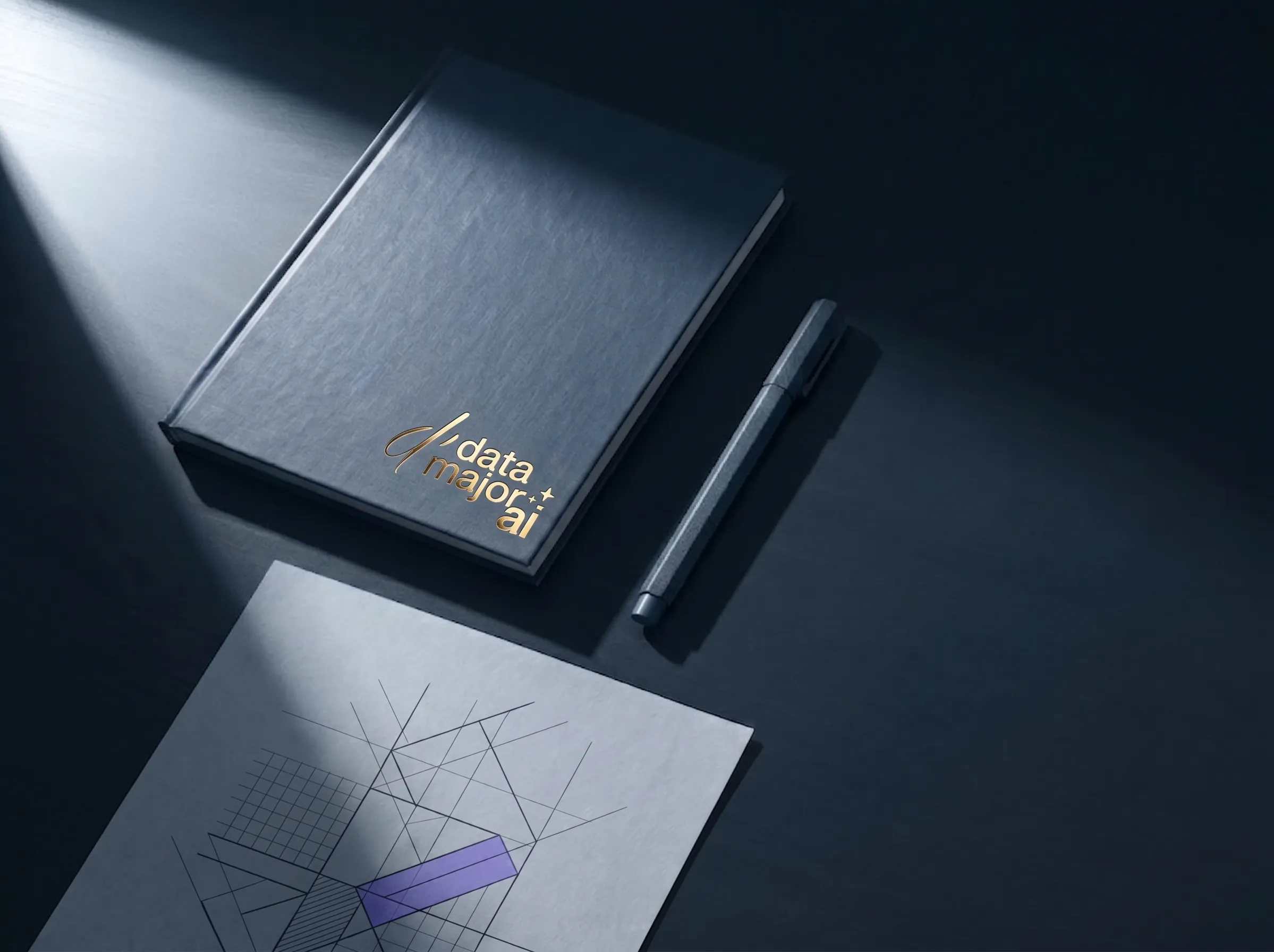Vue de dessus d’un carnet fermé frappé du logo data-major ai en violet, d’un stylo posé à côté et d’une feuille couverte d’un schéma géométrique dont une facette est colorée en violet ; un rai de lumière traverse la scène, la droite du cadre reste dans l’ombre.